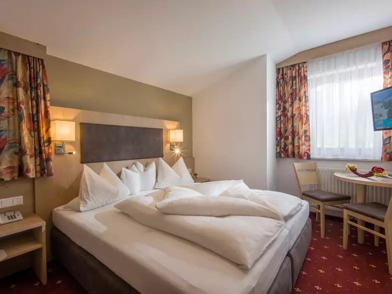 Mansardenzimmer mit zusätzlichem Wohnraum im alpinen Stil